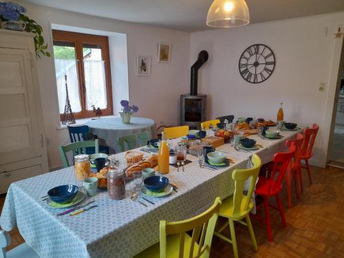 Raon-lès-LeauLa maison du vannier的用餐室配有带黄色和蓝色椅子的桌子