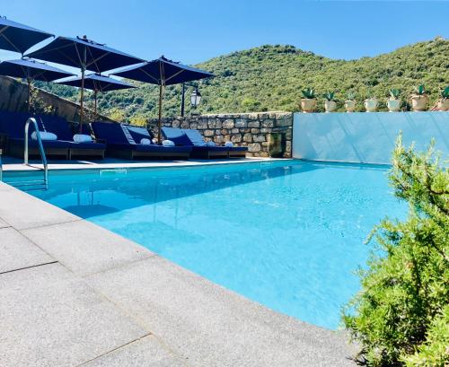 Banne邦镇酒店的一个带椅子和遮阳伞的游泳池