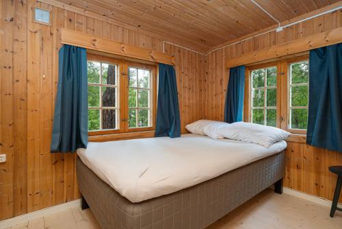 杜姆奥斯Ljoshaugen Camping的木墙和窗户的客房内的一张床位