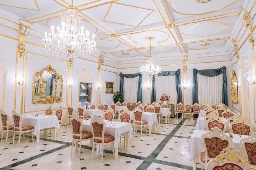 索普隆潘诺尼亚酒店 的用餐室配有白色桌椅和吊灯。