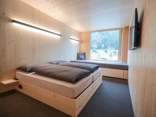 圣加伦基希Revier Mountain Lodge Montafon的一间小卧室,配有床和窗户