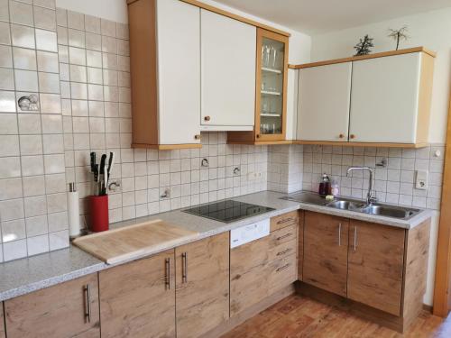菲尔根Ferienwohnung Mühlburger的一个带木制橱柜和水槽的厨房