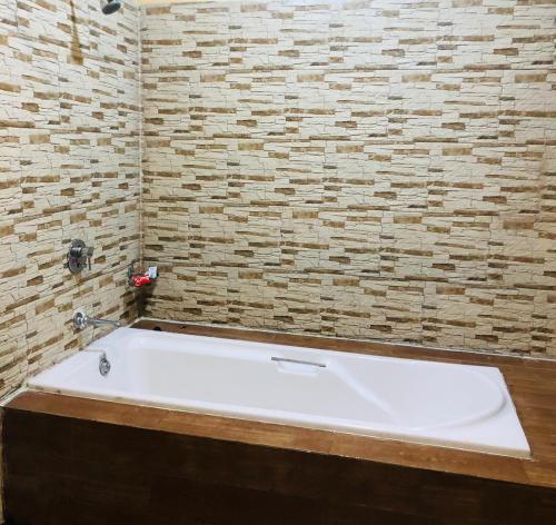 罗纳瓦拉Slice Of Heaven.3-Bedroom Villa with Pool & Gazebo的带浴缸的浴室和砖墙