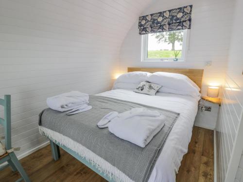 洛克比Laird Lodge 2的一间卧室配有一张带白色毛巾的床