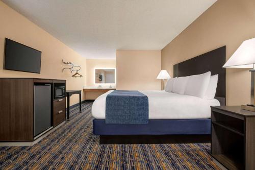 Lindsay林赛橄榄树速8酒店的配有一张床和一台平面电视的酒店客房