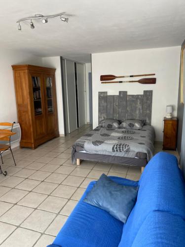 圣特罗让莱班Chambre indépendante dans une villa的一间卧室配有一张床和一张蓝色的沙发