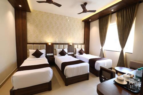 钦奈Mayuraa Residency的酒店客房设有两张床和一张桌子。