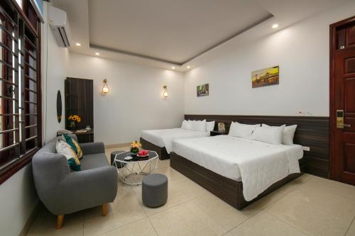 河内Hanoi Airport Suites Hostel & Travel的酒店客房,配有两张床和椅子