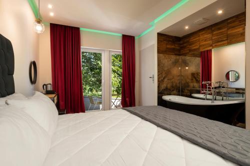 圣安德里斯伯格Angelo Spa Resort的卧室配有一张白色大床和浴缸