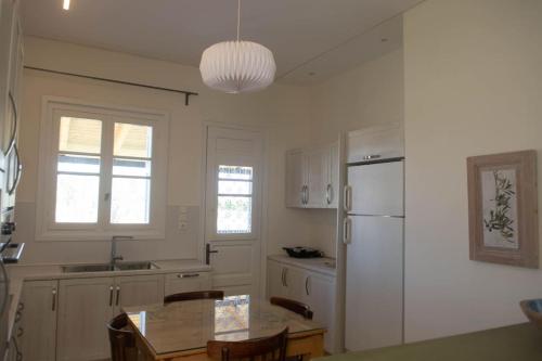 美西尼G&N APARTMENT的厨房配有桌子和白色冰箱。