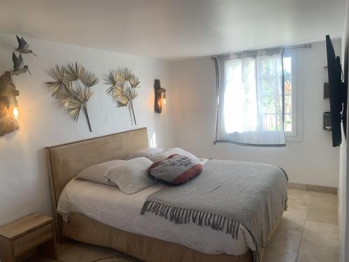 圣马迪拉莫Appartement Domaine du soleil couchant的一间卧室配有带两个枕头的床和窗户