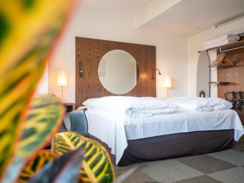 奥本罗欧洲酒店的一间卧室配有一张带镜子和椅子的床