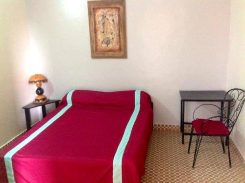 瓦加杜古卡瓦纳酒店的卧室配有1张床、1张桌子和1把椅子