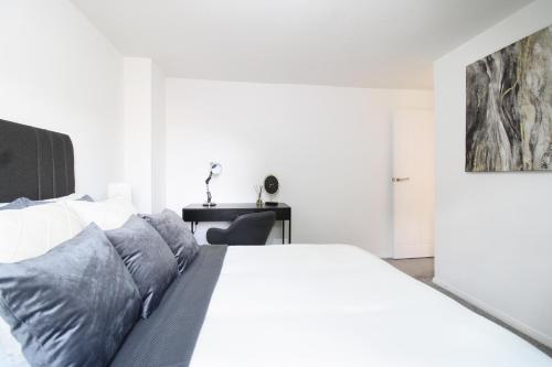 艾尔斯伯里Virexxa Aylesbury Centre - Deluxe Suite - 3Bed House with Free Parking的卧室配有白色的床和书桌