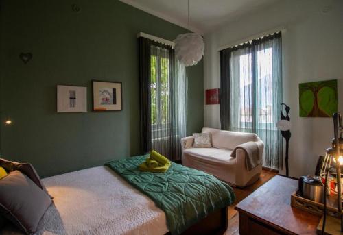 洛迦诺雅特别墅旅馆的一间卧室配有一张床、一张沙发和一把椅子