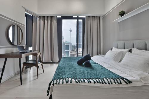 吉隆坡H&N Luxury Suites KLCC的一间卧室配有一张带书桌的床和窗户。