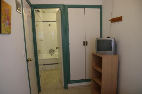 卡塔亚坎波马旅馆的一间配有电视的房间和通往浴室的门