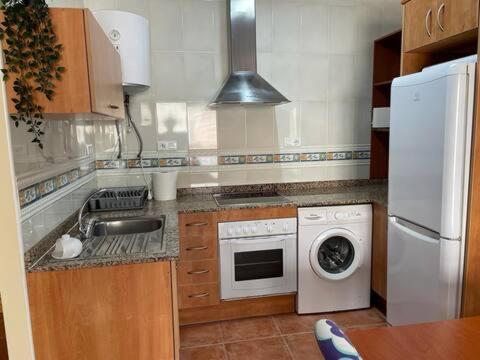 莱斯卡瑟斯-达尔卡纳Apartamento en la playa的厨房配有水槽和洗衣机