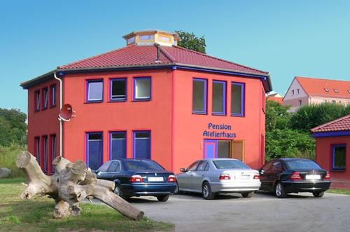 萨斯尼茨Pension Sassnitz Atelierhaus的停车场内有车辆的建筑物