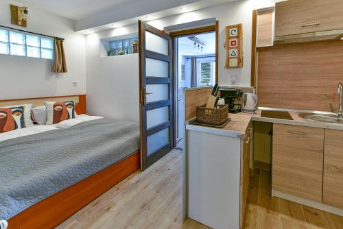上塔尔卡尼Pitypang Apartman Felsőtárkány的一间卧室配有一张床,厨房配有水槽