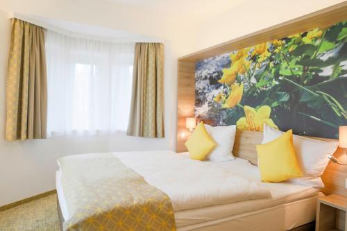 米特尔巴赫R&R Residenzen HOTEL的酒店客房设有一张床,墙上挂有绘画作品