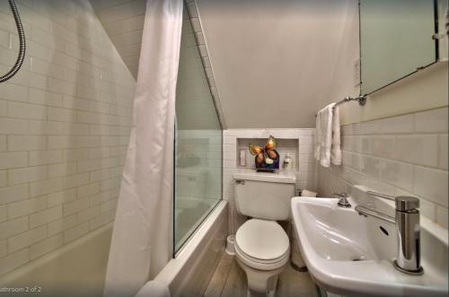 魁北克市莱斯曼蒙卡姆公寓的浴室配有卫生间、浴缸和水槽。