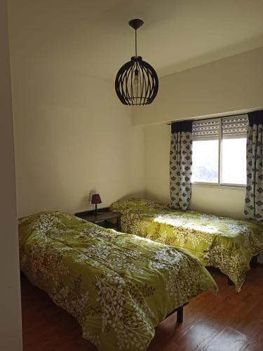 罗萨里奥HERMOSO DEPARTAMENTO的一间卧室配有两张床和吊灯。