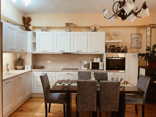 阿克雷迪斯Andreas Village 2的厨房配有白色橱柜和桌椅