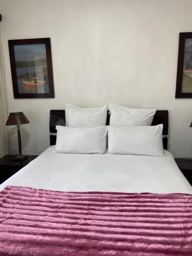 马盖特Unit 3, Marine Terrace的卧室配有一张白色大床和紫色毯子