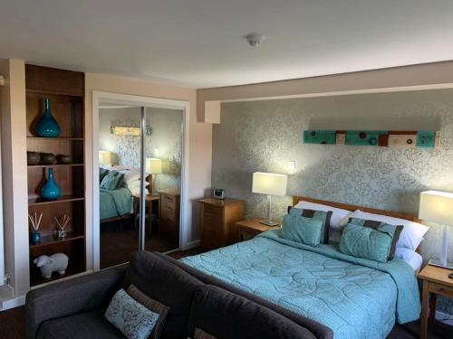 彭里斯Ullswater Suite的一间卧室配有蓝色的床和沙发