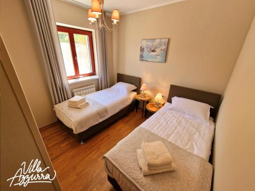 巴萨尼加Villa Azzurra的一间卧室设有两张床和窗户。