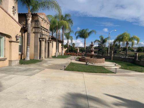 里弗赛德LuxHome Suites的一座公园,公园里拥有喷泉和棕榈树,还有一座建筑