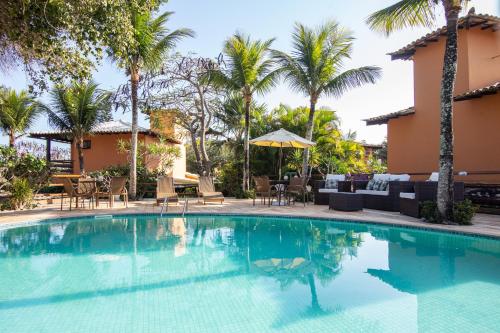 布希奥斯Casa em Búzios com vista mar e piscina | EDF 12的一个带桌椅的游泳池,棕榈树