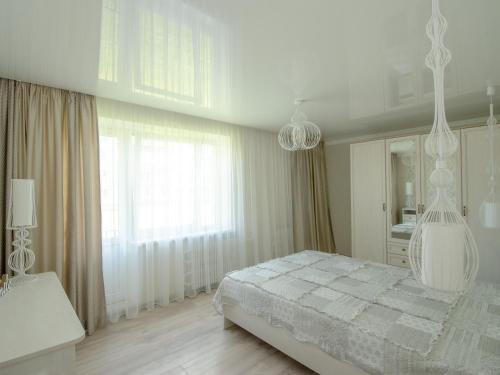 文茨皮尔斯Jūras 4 Apartament的白色的卧室设有床和大窗户