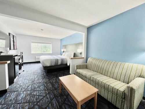 昆西AmericInn by Wyndham Quincy的酒店客房,配有床和沙发