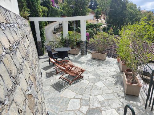 拉帕洛Rapallo Summer House的天井配有桌椅和盆栽植物