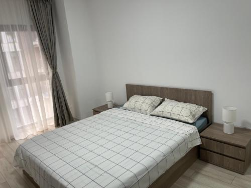 布加勒斯特Moghioros Park Residence Apartment的卧室配有白色的床、两个枕头和窗户