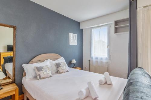 拉罗谢尔Appartement Petit coin de paradis - Welkeys的一间卧室配有一张带白色床单的床和一扇窗户。