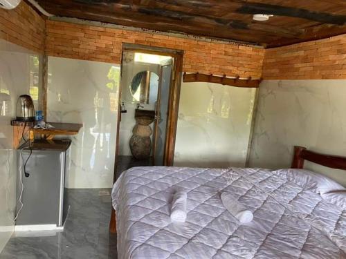 吉仙绿竹苑度假村的一间卧室设有一张床和木制天花板
