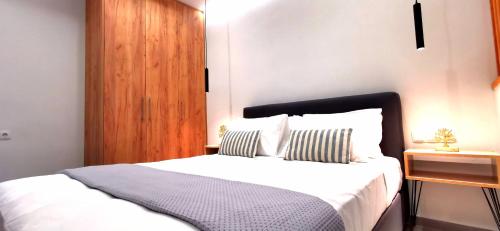 海若克利欧Urban Luxus Studio II的卧室配有白色的床和木制床头板