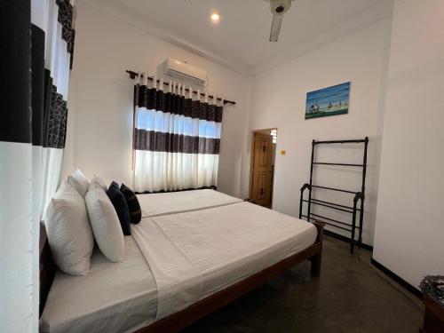 高尔拉伊鲁别墅酒店的一间卧室配有带白色床单和枕头的床。