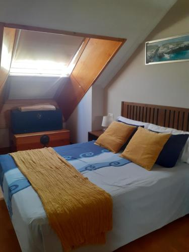 里瓦德奥Atico céntrico con piscina comunitaria的一间卧室配有黄色和蓝色枕头的床