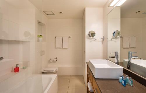 特拉维夫West Tel Aviv- All Suites Hotel By The Sea的白色的浴室设有水槽和卫生间。