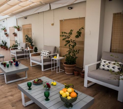 塞维利亚Jardin de la Alameda Hostal Boutique的一间配备有沙发及水果桌的客房