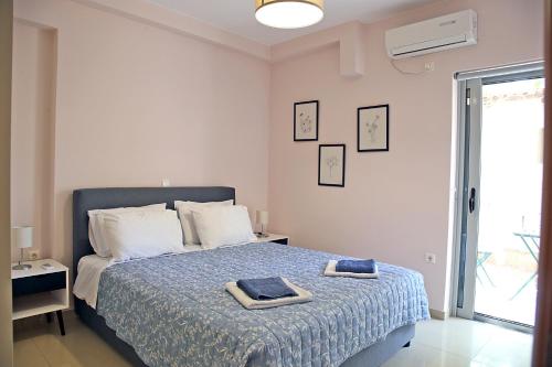 斯巴达2 Bedroom Apartment near the Athens Airport, Spata的一间卧室配有一张床,上面有两条毛巾