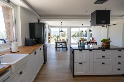 科维良Quinta da Sra Marocas的厨房配有白色橱柜和黑色冰箱。