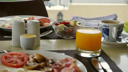 开普敦Sundown Manor Guest House的一张桌子,上面放着一盘食物和一杯橙汁