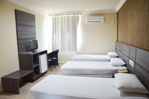 里约布兰科伊纳西奥宫酒店的酒店客房设有三张床和电视。