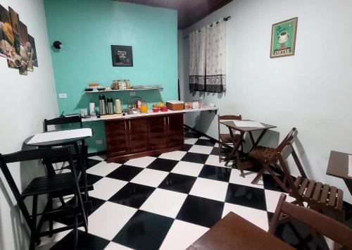 巴拉那瓜Hotel Serra do Mar的客房铺有 ⁇ 格地板,配有桌椅