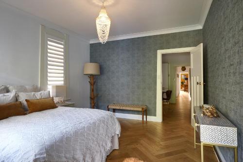 悉尼kookaburra beach house coogee的卧室设有白色的床和走廊
